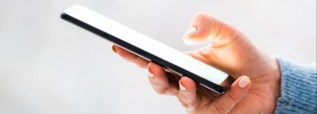 Billede af hånd der holder en mobiltelefon